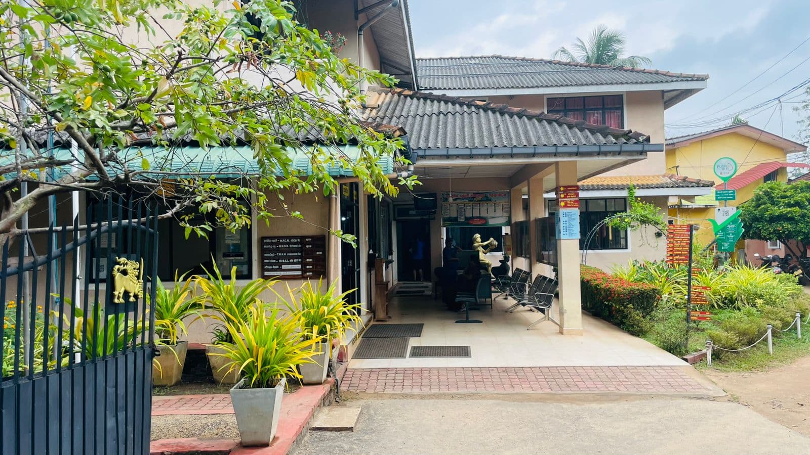 The Divisional Secretariat office at Mallawapitiya, its tiled portico opening onto a planted forecourt.